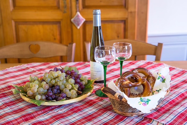 Bretzel, raisins et vin d’Alsace sur une nappe à carreaux
