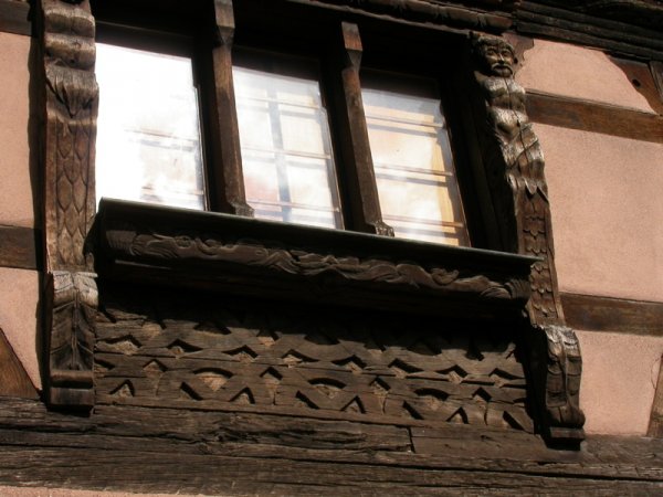 Un oriel en bois sculpté au-dessus d’une rue