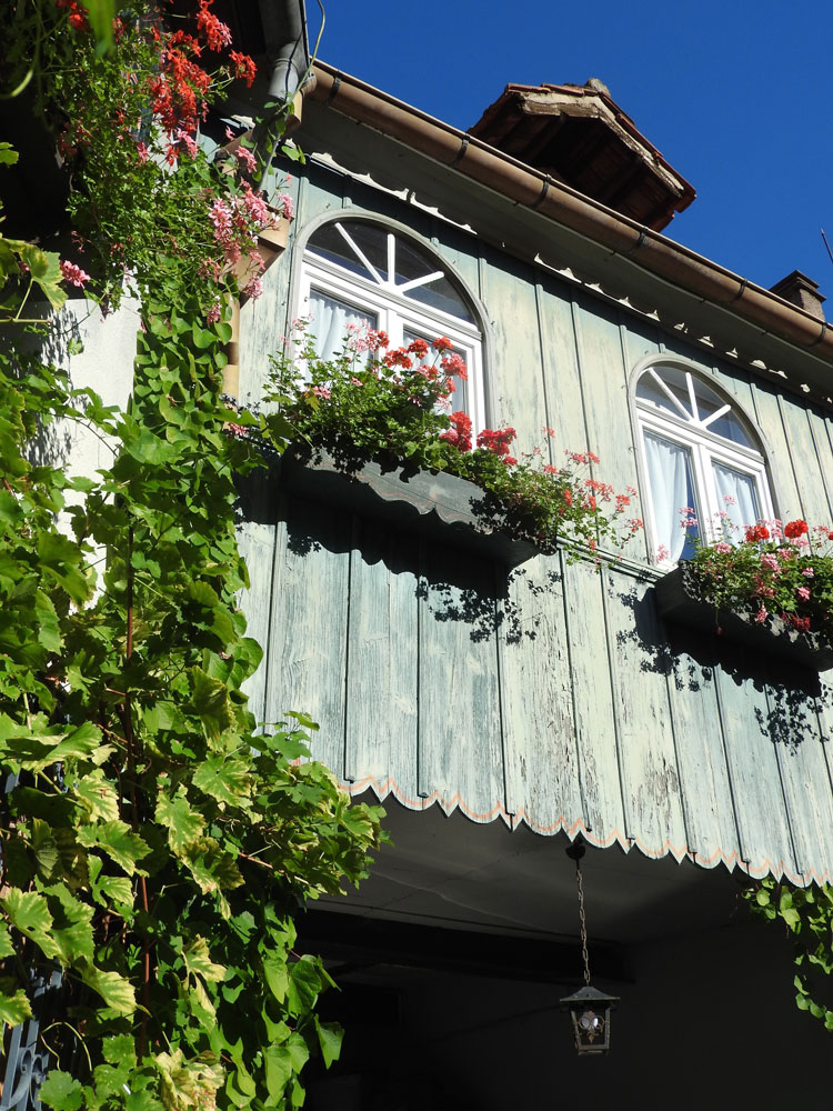 Les balcons fleuris de géraniums de la maison, côté cour