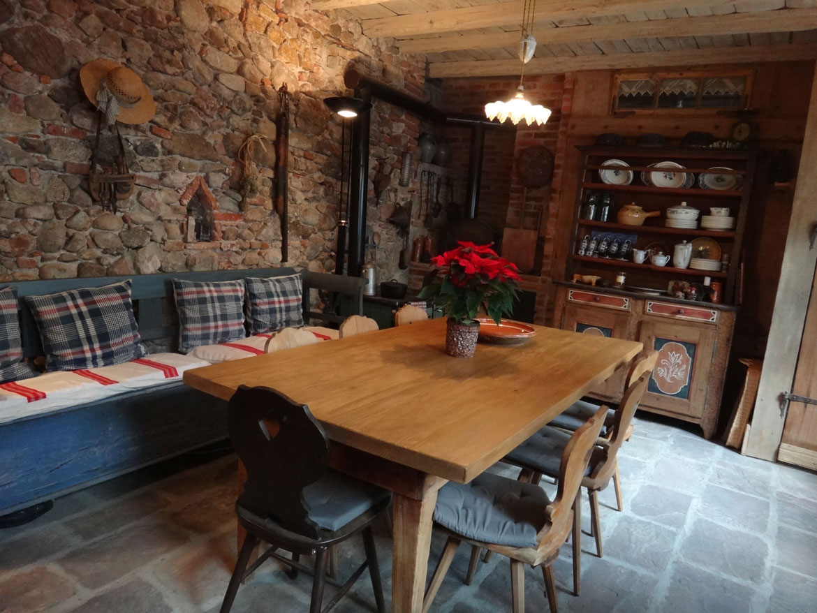 Une table dressée dans une salle aux murs de pierre et au poêle ancien