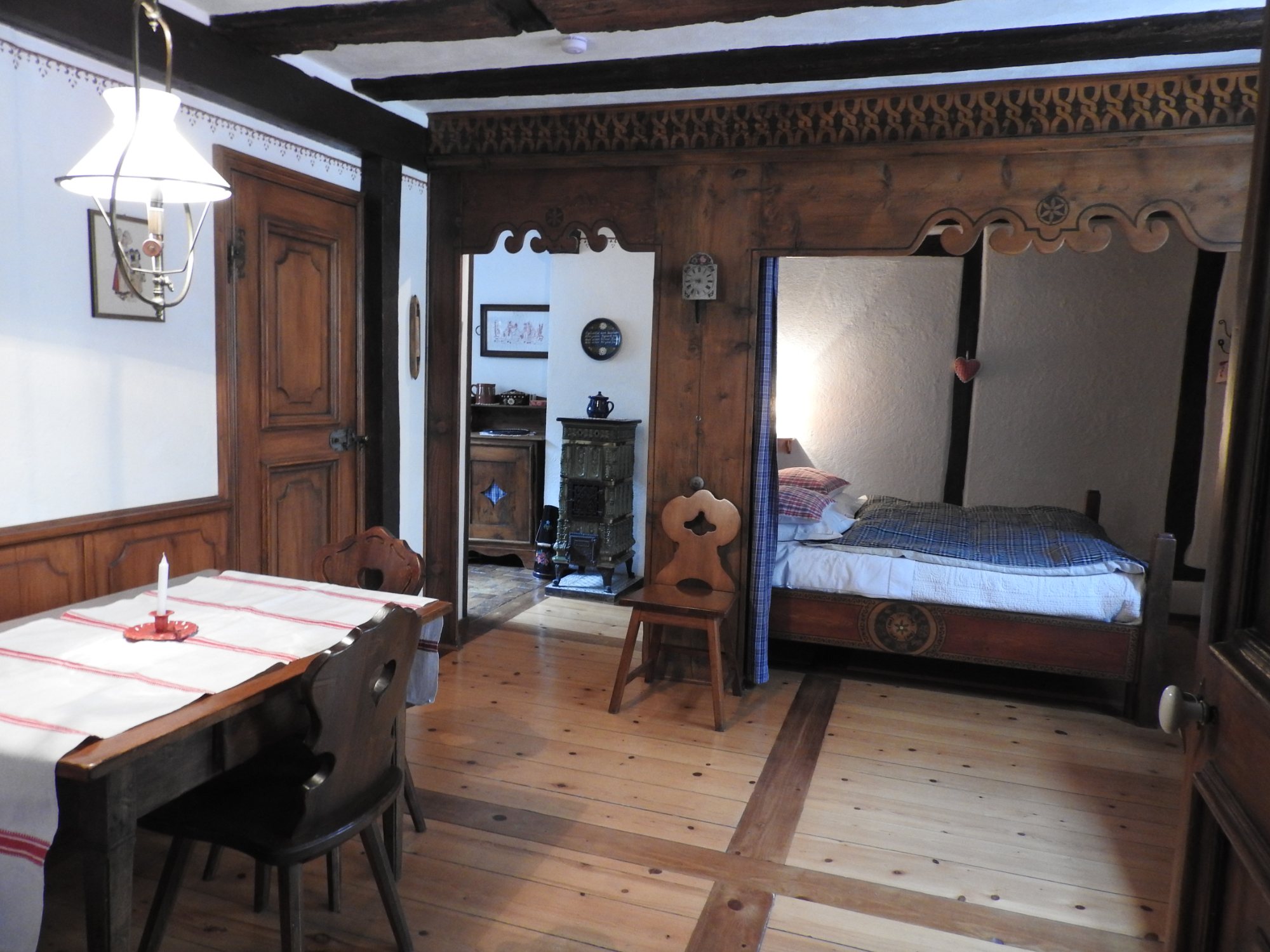 Vue d’ensemble de la pièce, de la table au lit